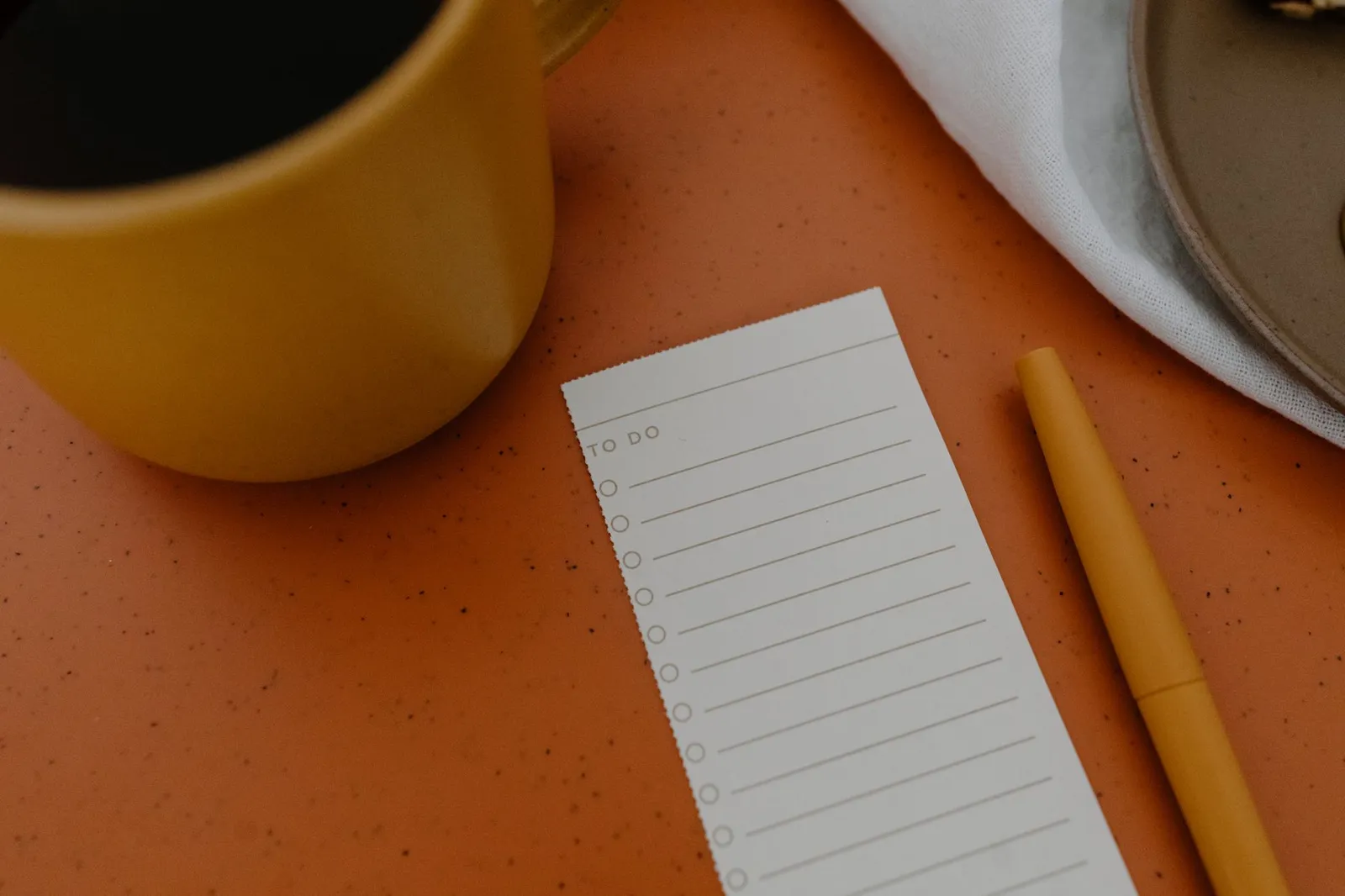 A notebook of tracked habits and progress beside a laptop