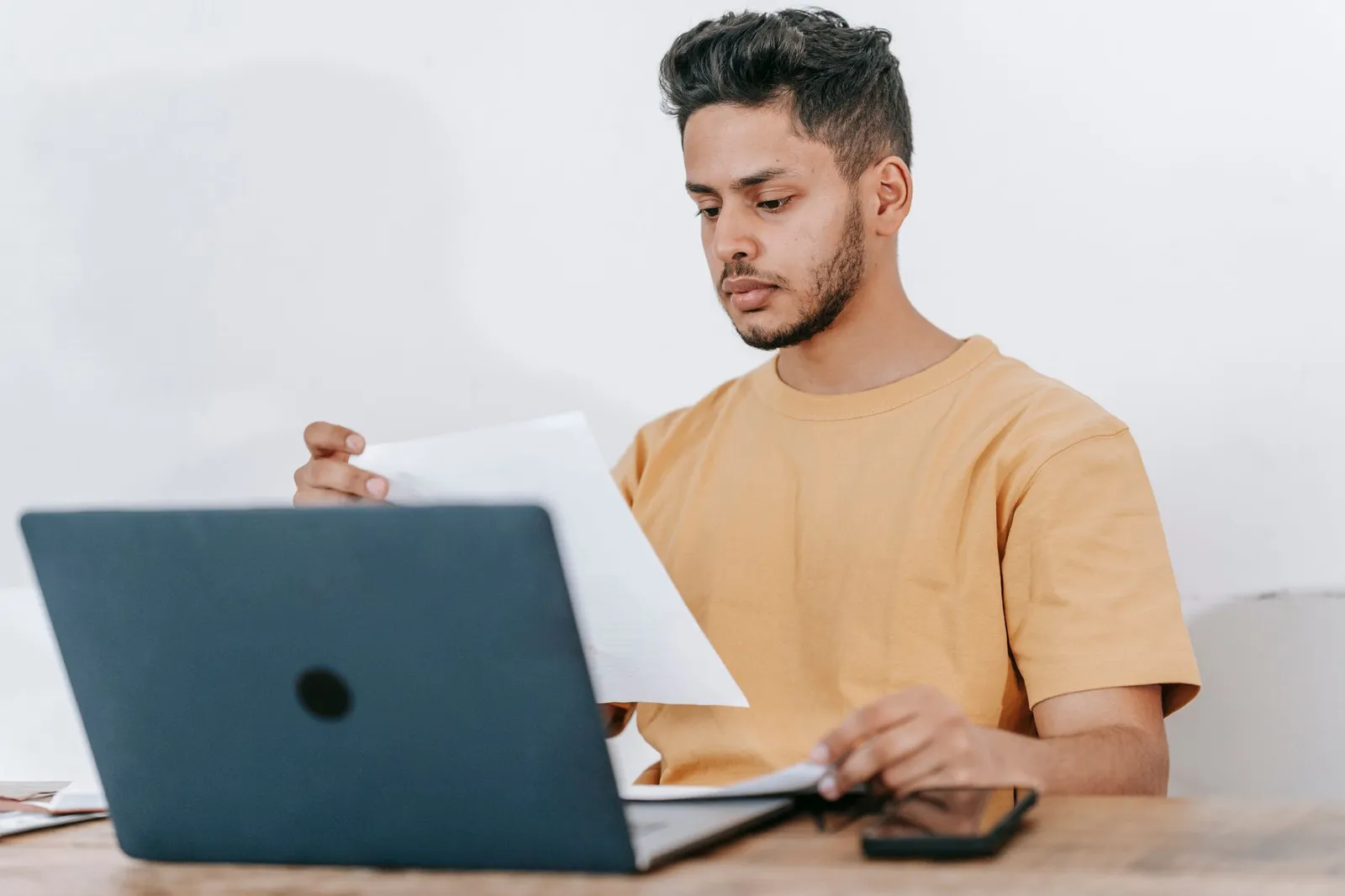 A freelancer reviewing a proposal and invoice on a laptop