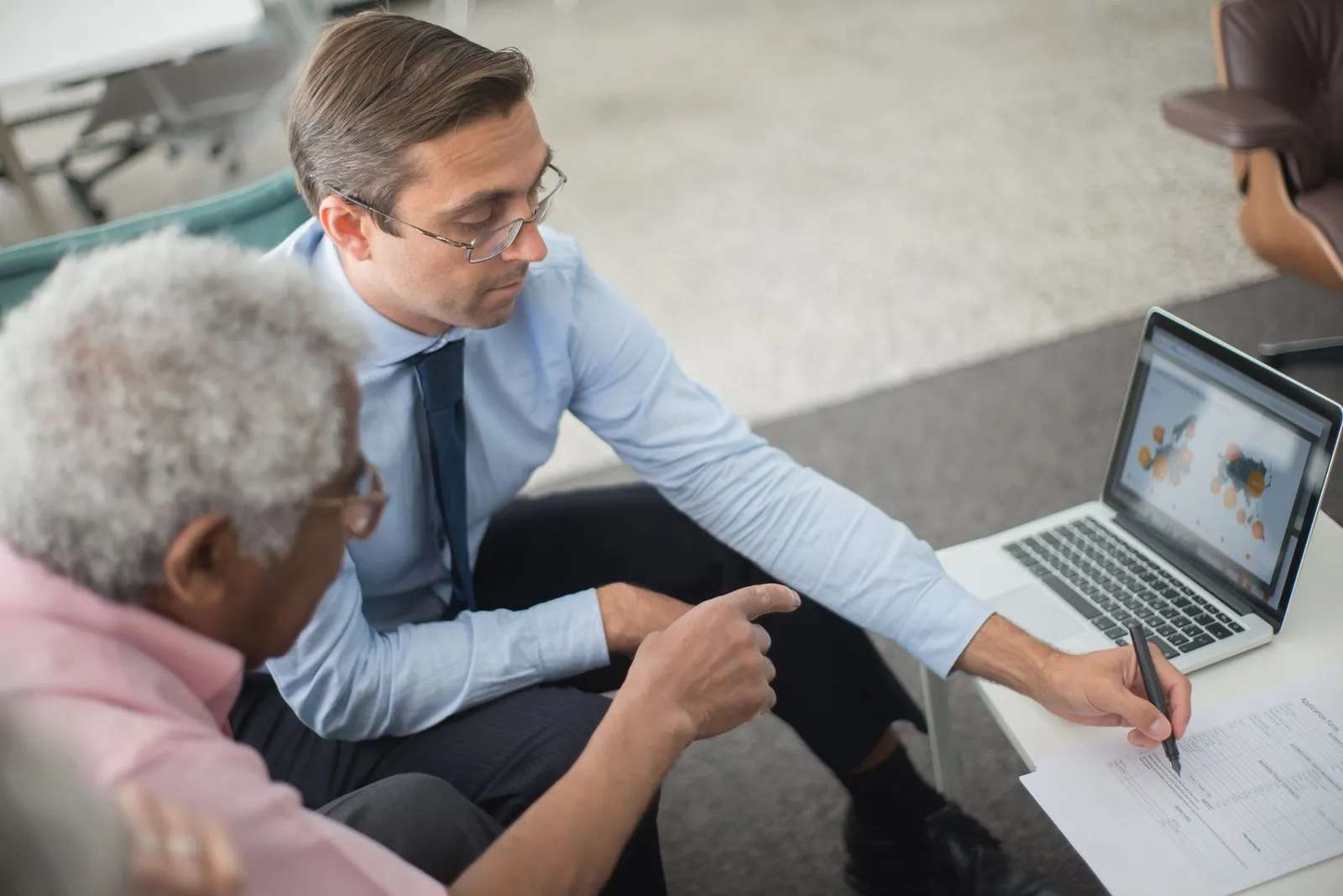 Two people reviewing a project plan on a laptop