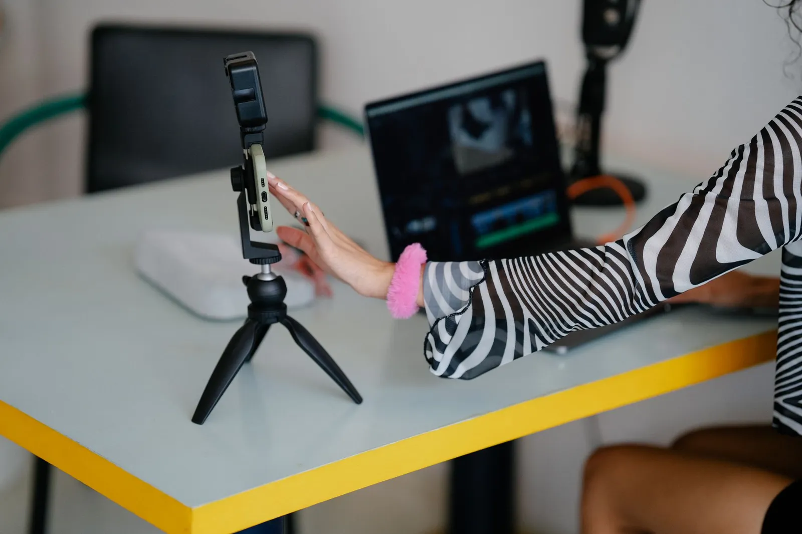 A coach recording course material at a desk with a laptop and microphone